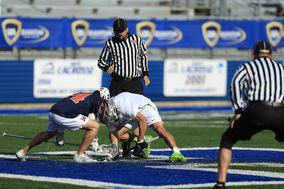A NCLOA lacrosse official watching players faceoff.